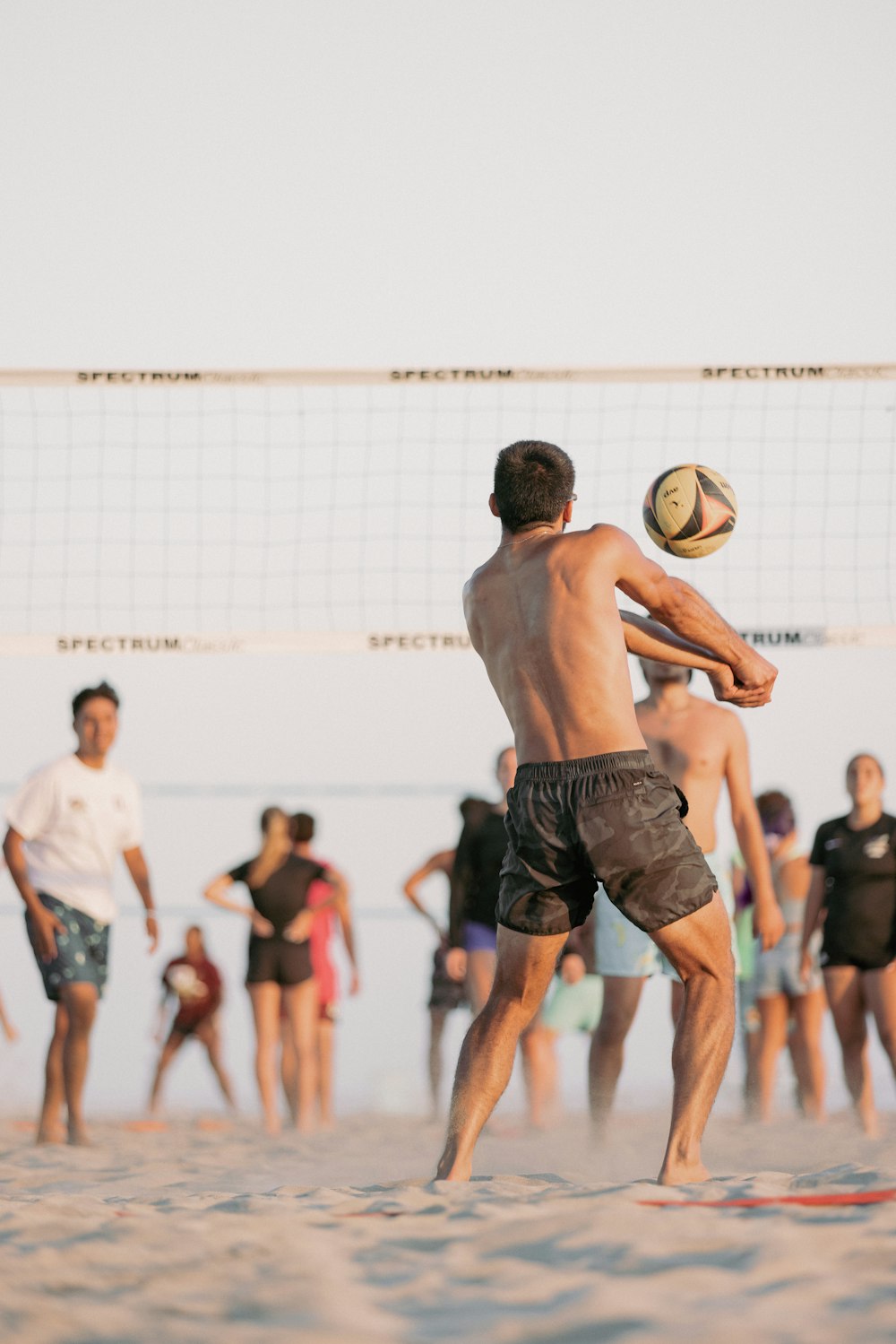 a group of people playing volleyball on the beach