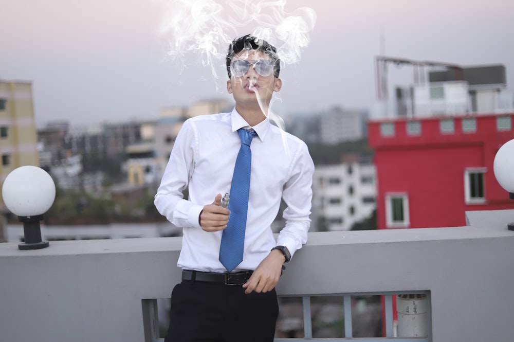 a man wearing a tie and smoking a cigarette