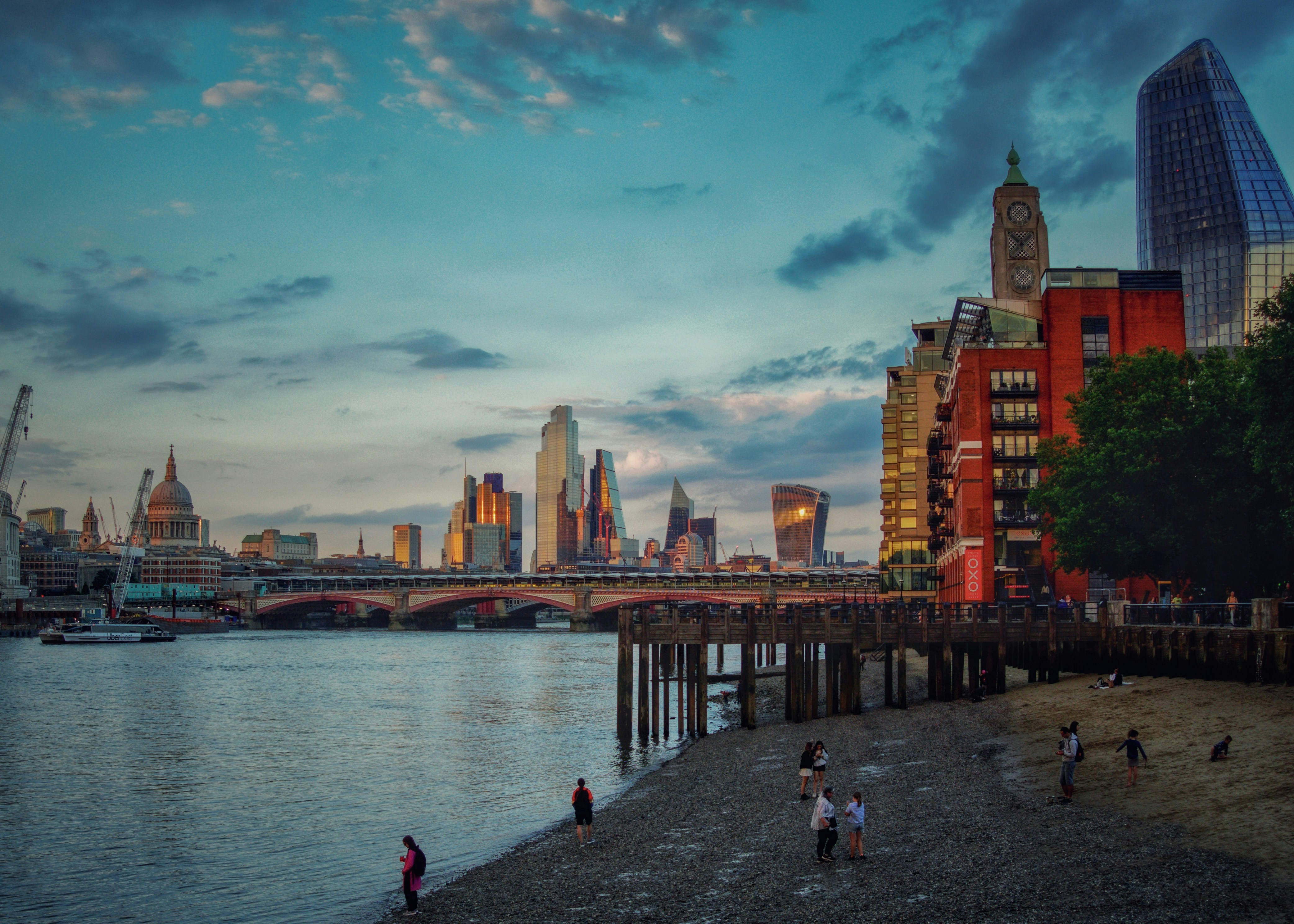 a group of people standing on a beach next to a body of water