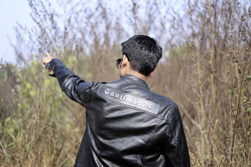 a man in a leather jacket pointing to something