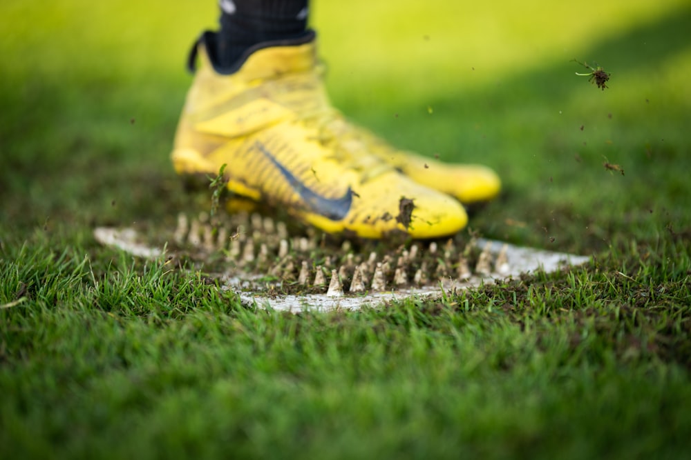 a soccer player's foot on a soccer ball in the grass