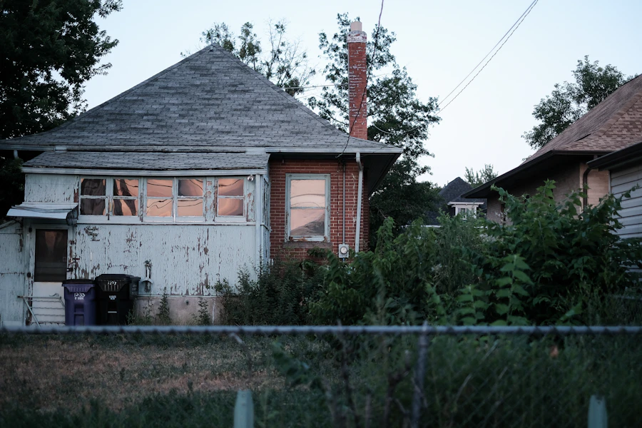 An old cottage with a brick chimney and overgrown yard
