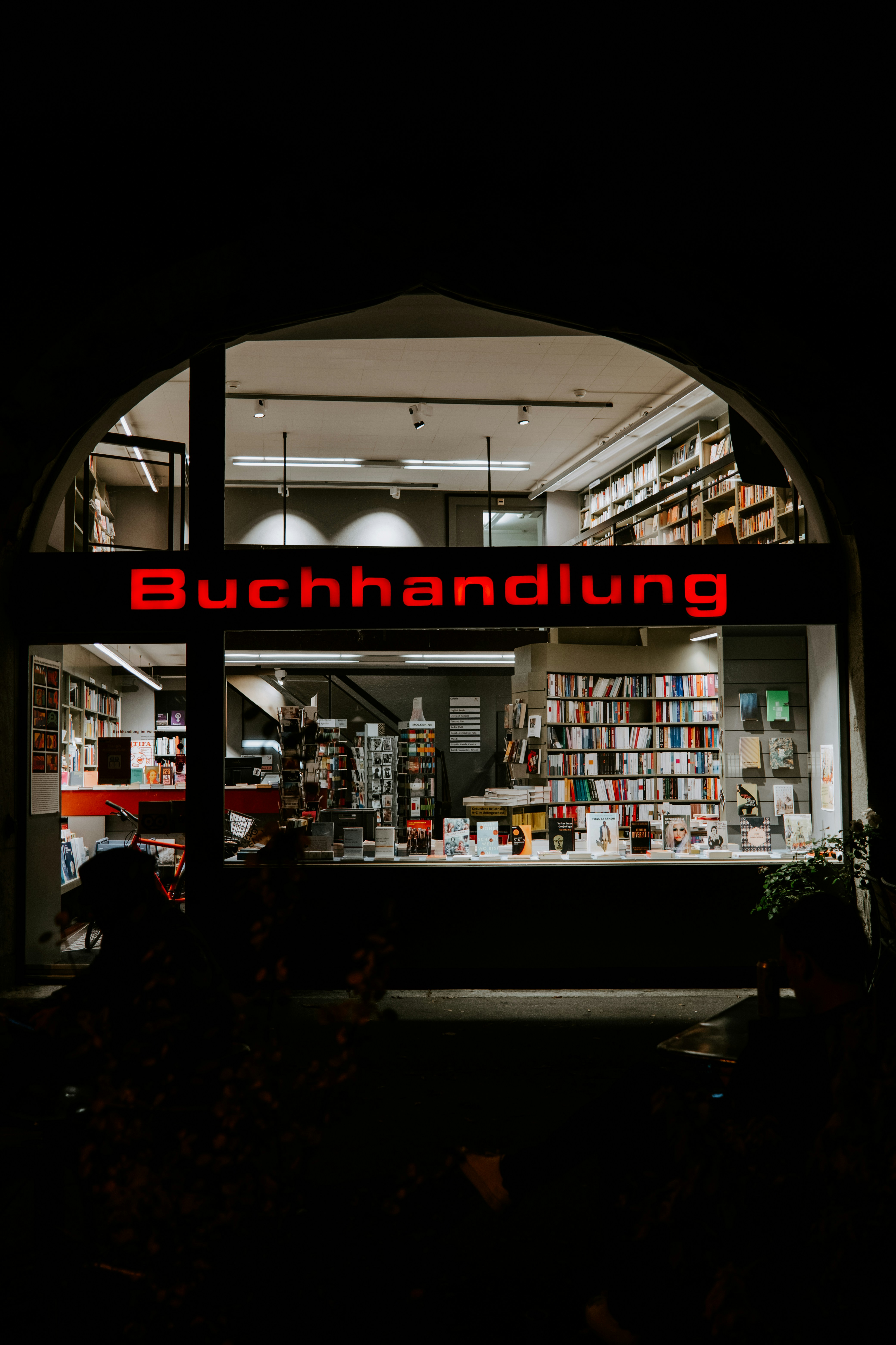 a book store with a lit up sign in the window