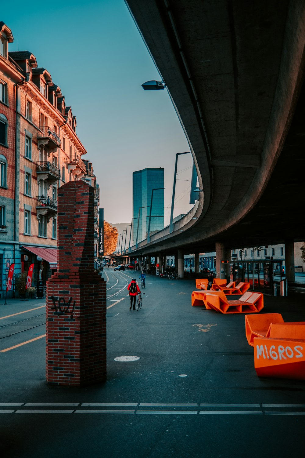 a man riding a bike down a street next to tall buildings