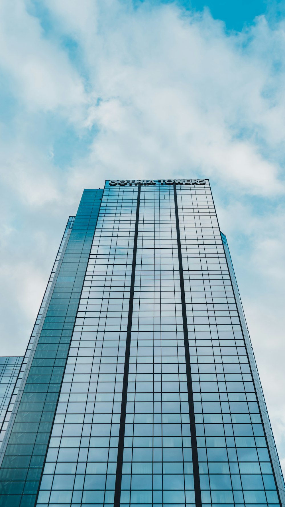 a tall glass building with a sky background