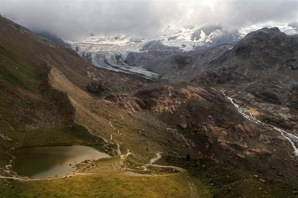 an aerial view of a mountain range with a lake in the foreground