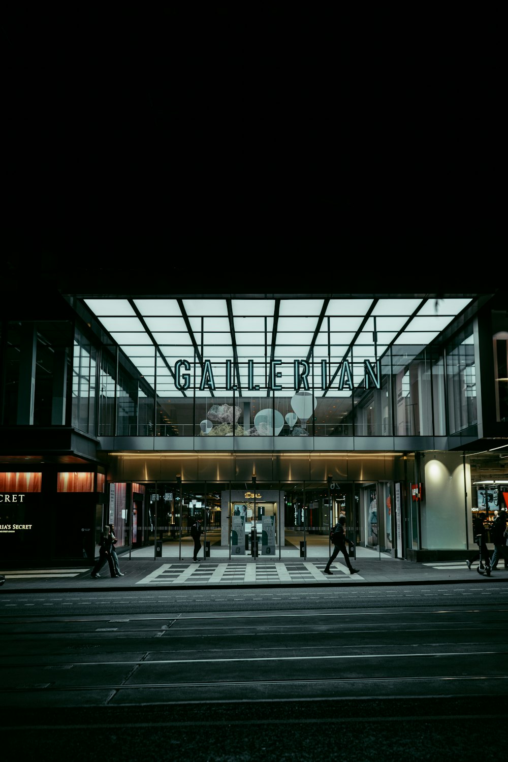 people walking in front of a building at night