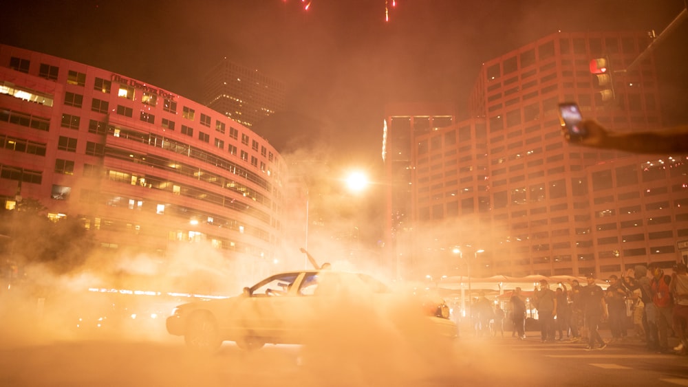 a car driving down a street next to tall buildings