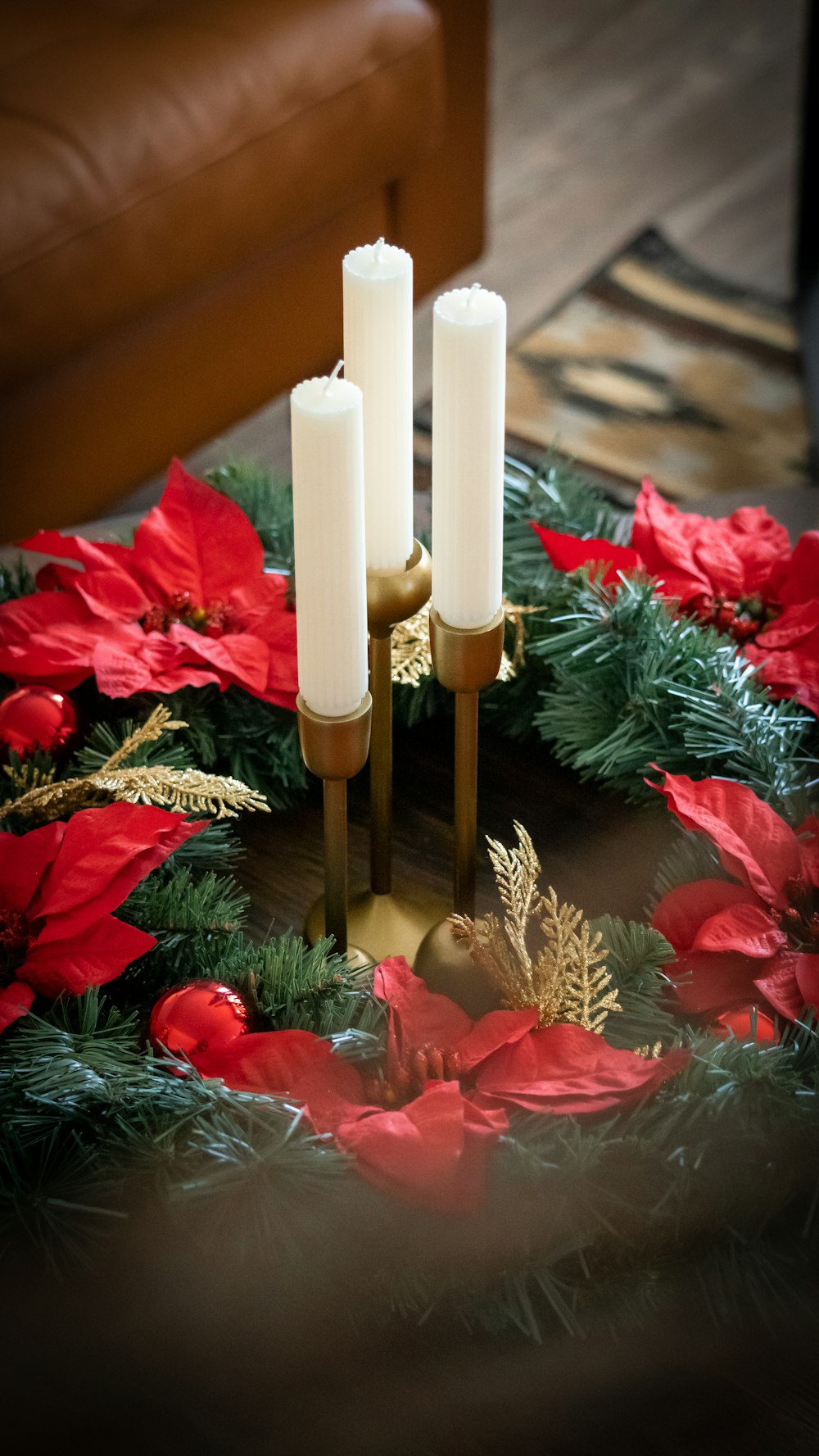 a christmas wreath with three candles on top of it