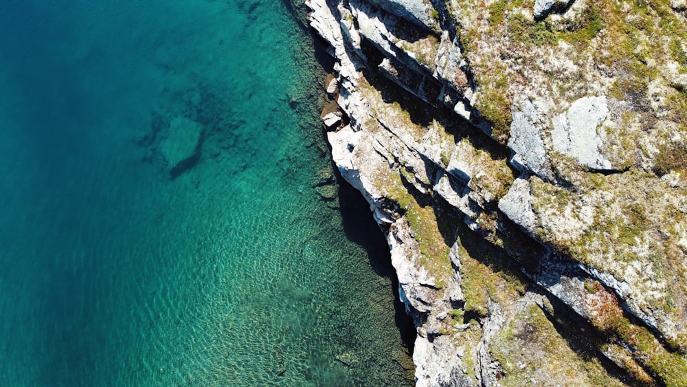 an aerial view of a body of water near a cliff