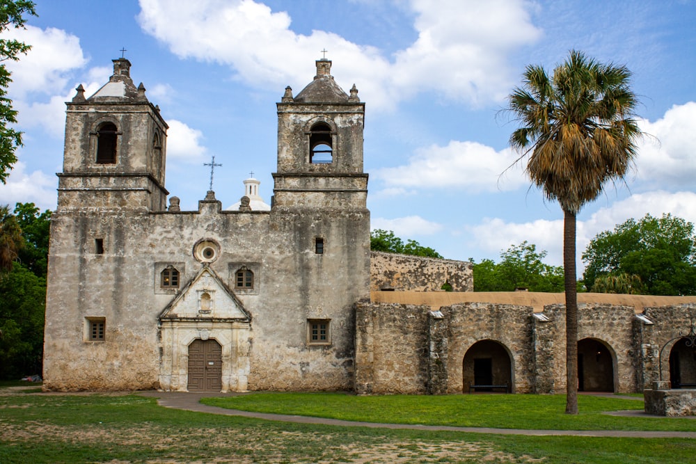 an old church with a palm tree in front of it