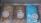 Three tubs of ice cream with distinct colors and labels are placed in a display freezer. The leftmost tub is filled with brown ice cream labeled 'Ovaltine Regal', the middle tub contains a lighter brown ice cream named 'Bonbon', and the rightmost tub showcases a bright blue colored ice cream called 'Azzurro'. Each tub has a small sign with the corresponding flavor name placed on top.