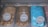 Three tubs of ice cream with distinct colors and labels are placed in a display freezer. The leftmost tub is filled with brown ice cream labeled 'Ovaltine Regal', the middle tub contains a lighter brown ice cream named 'Bonbon', and the rightmost tub showcases a bright blue colored ice cream called 'Azzurro'. Each tub has a small sign with the corresponding flavor name placed on top.