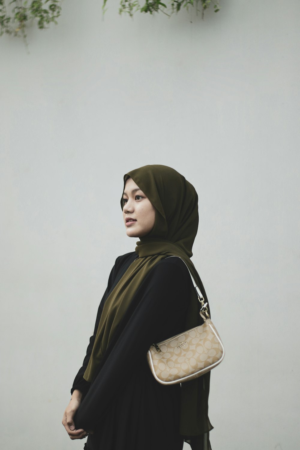 a woman in a hijab carrying a purse