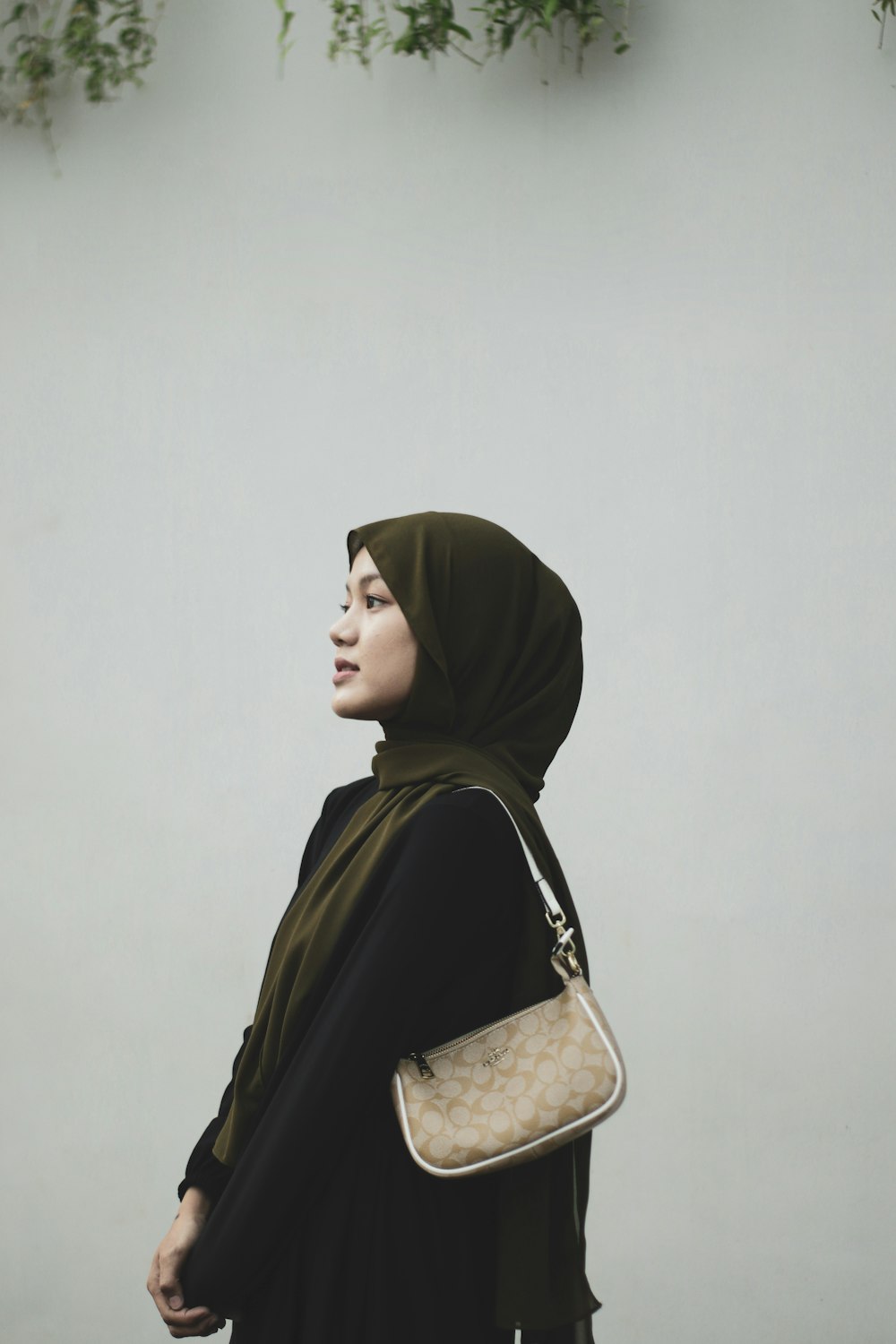 a woman in a hijab carrying a purse