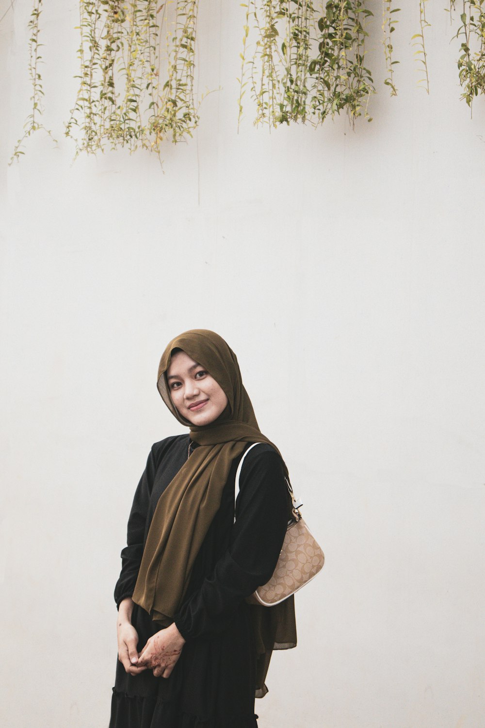 a woman standing in front of a white wall