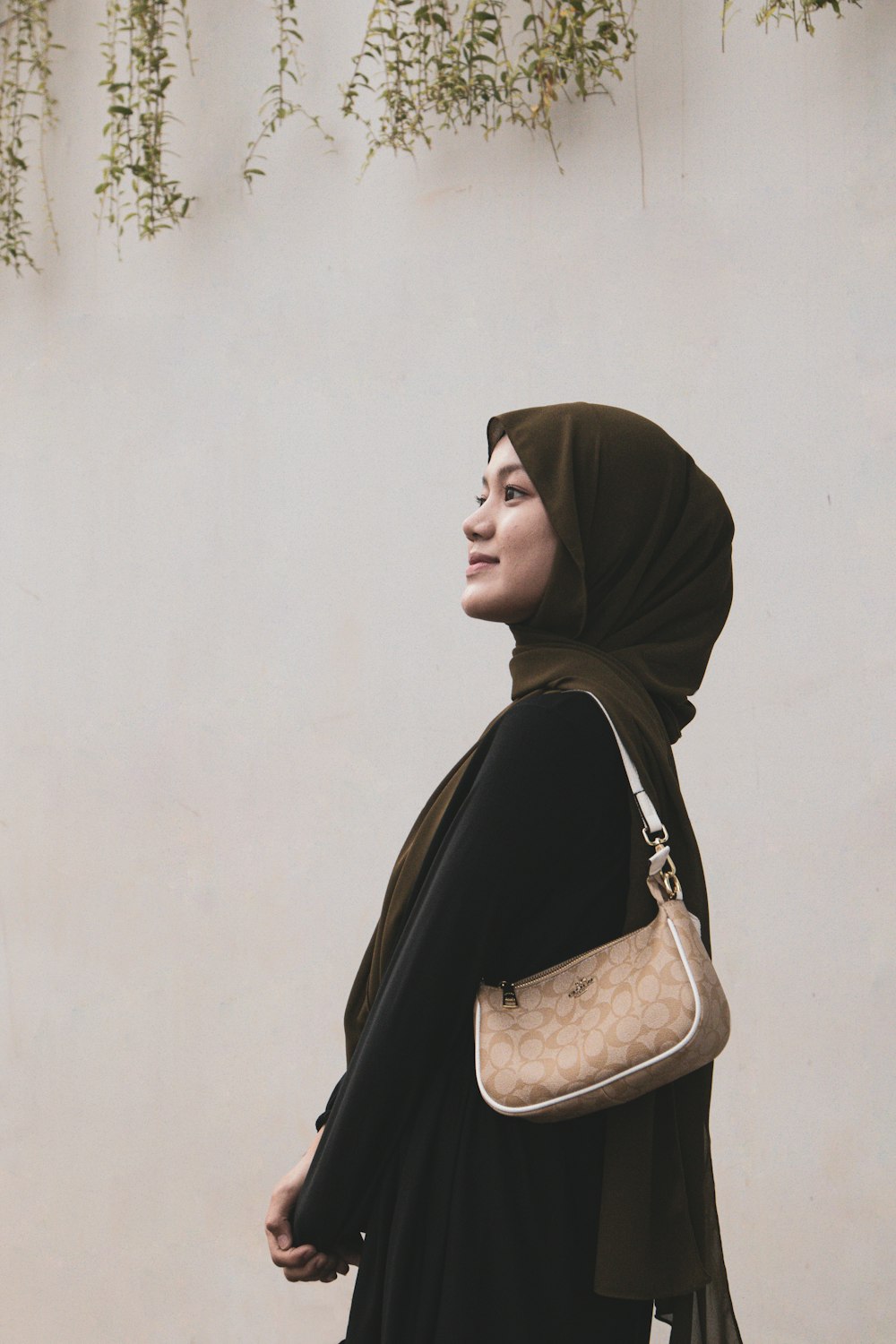 a woman in a hijab carrying a purse