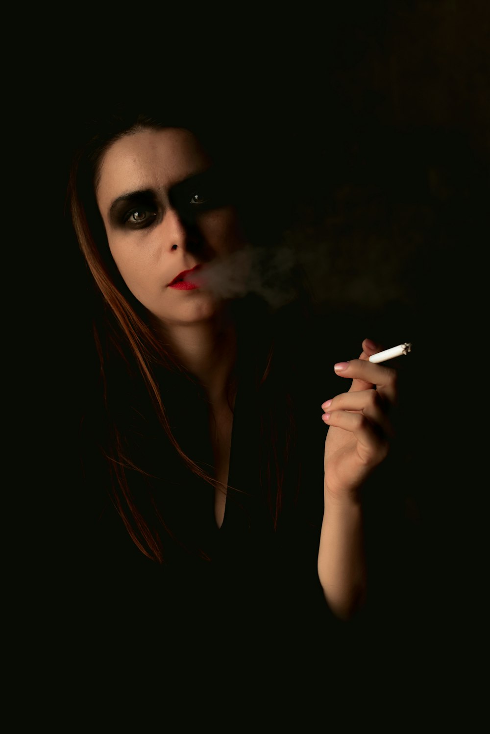 a woman smoking a cigarette in the dark