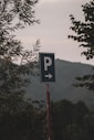 a blue parking sign sitting on the side of a road