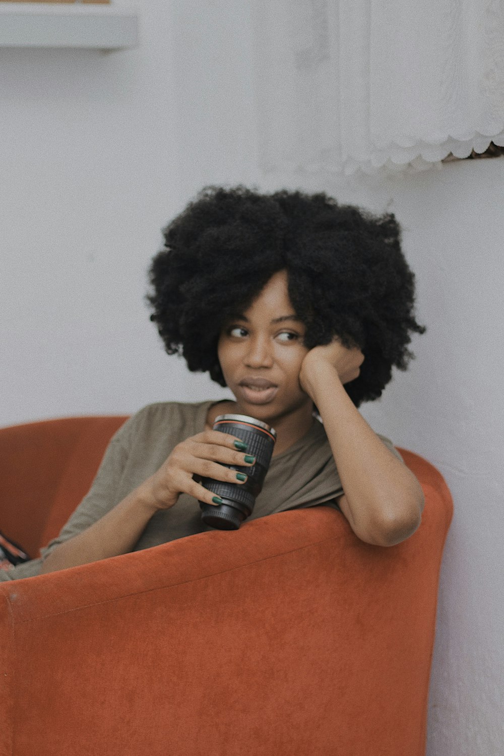 a woman sitting in a chair with a can of soda