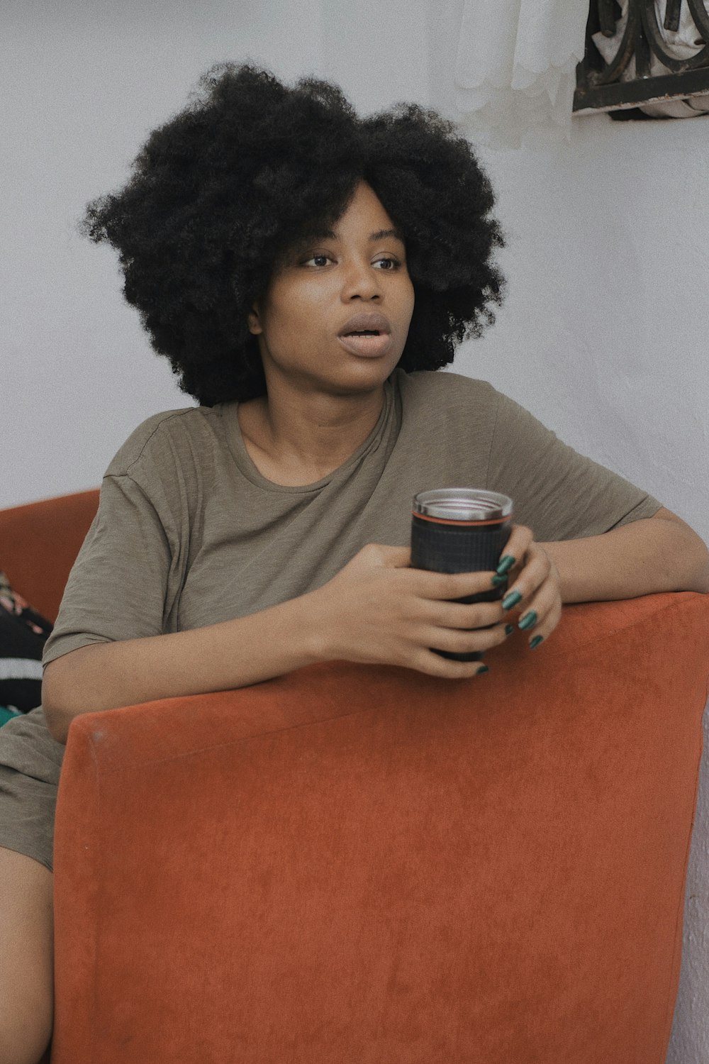 a woman sitting on a couch with a cup of coffee
