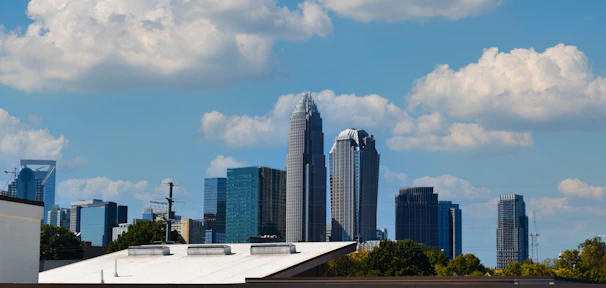 A modern urban skyline with green rooftop gardens under a clear blue sky.