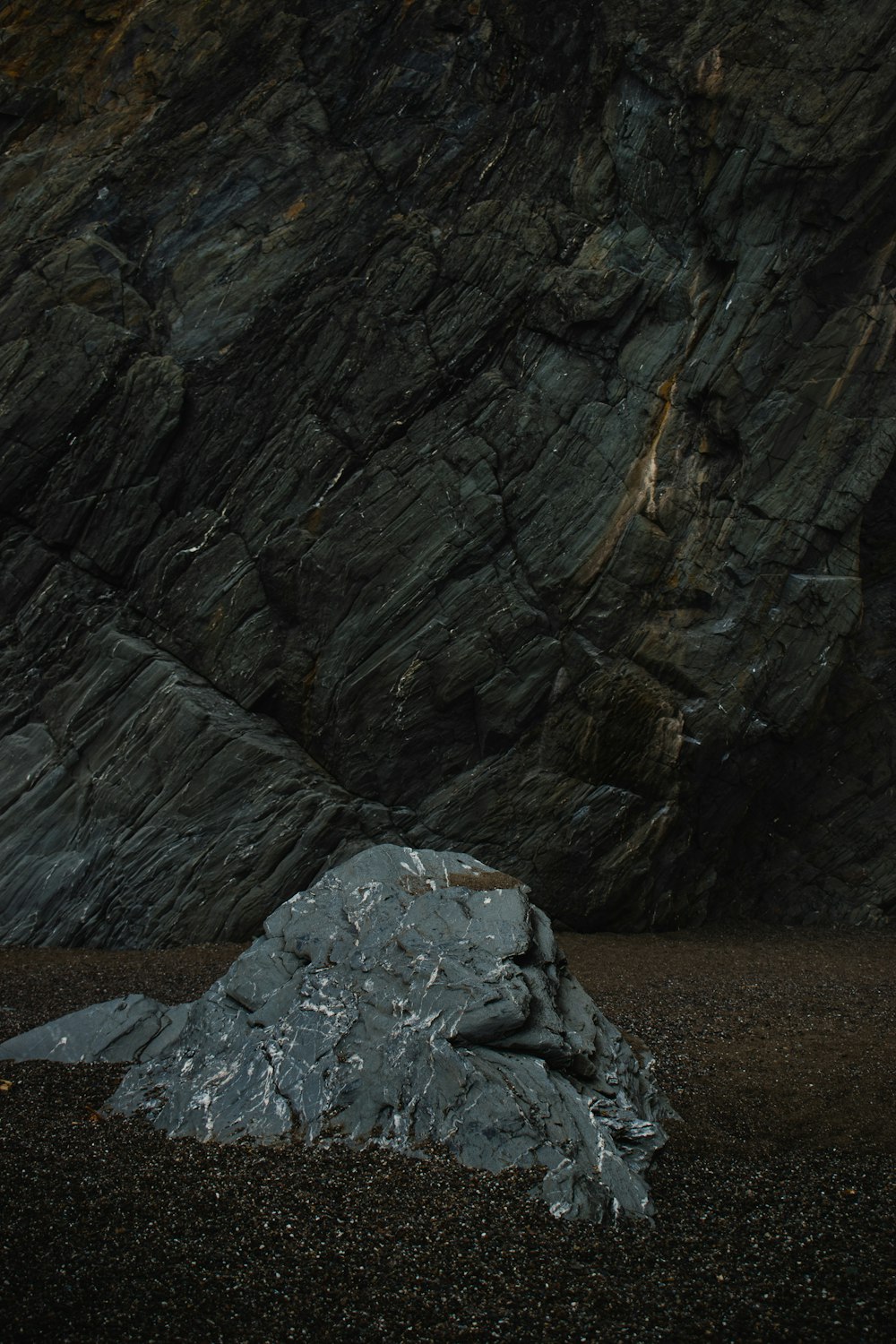 a large rock sitting on top of a sandy beach