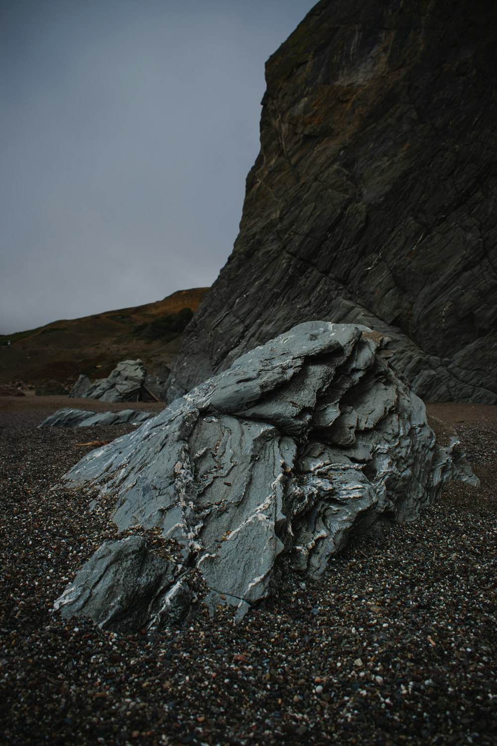 a large rock sitting on top of a rocky beach