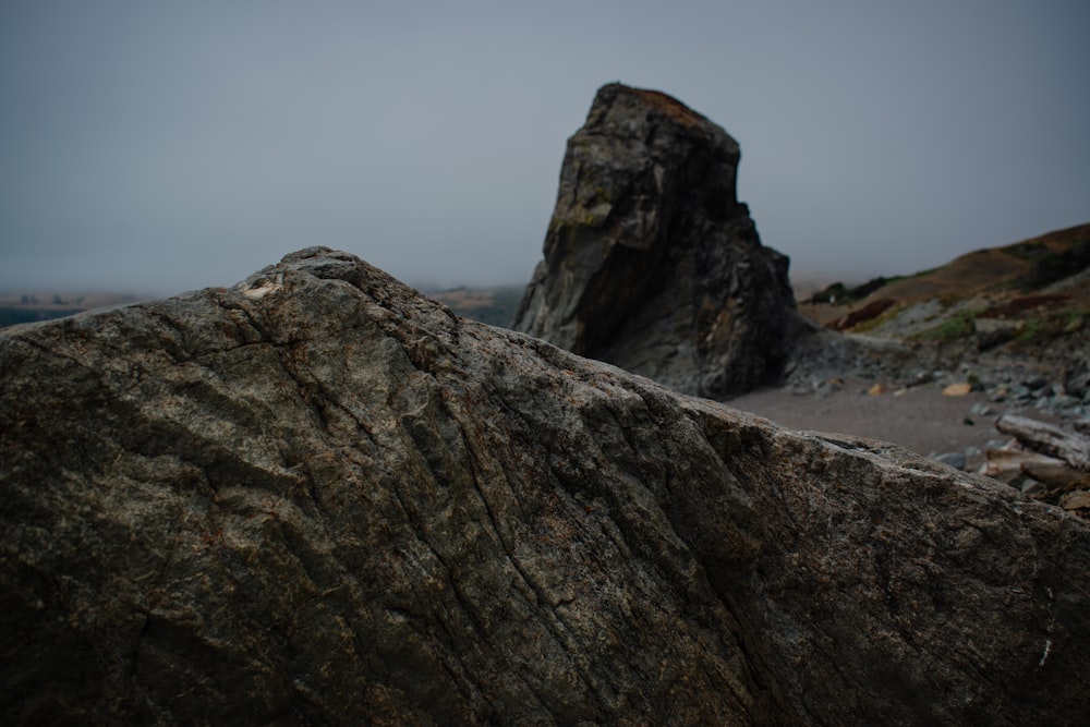 a large rock sitting on top of a sandy beach