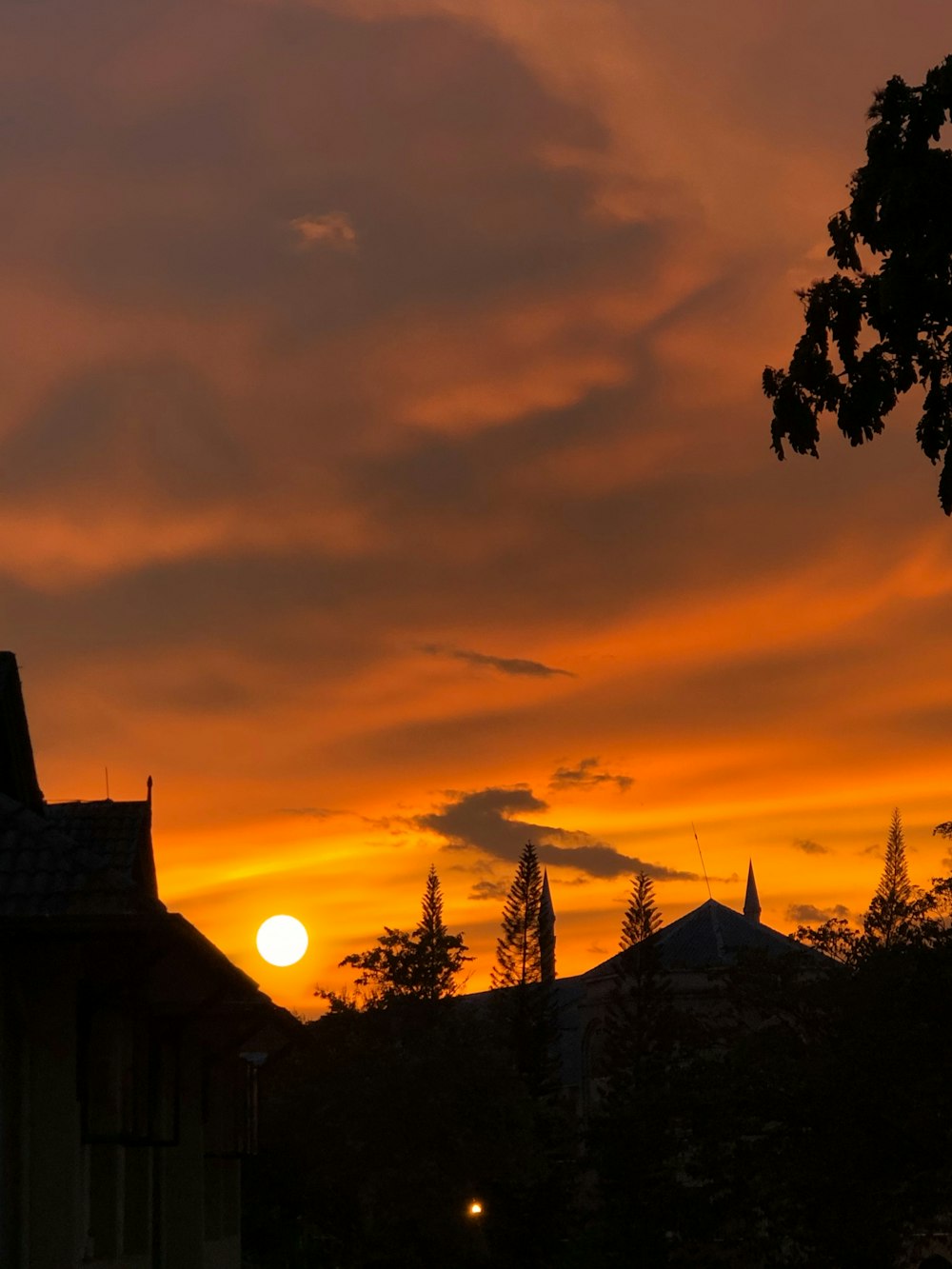 the sun is setting behind a building with a clock tower