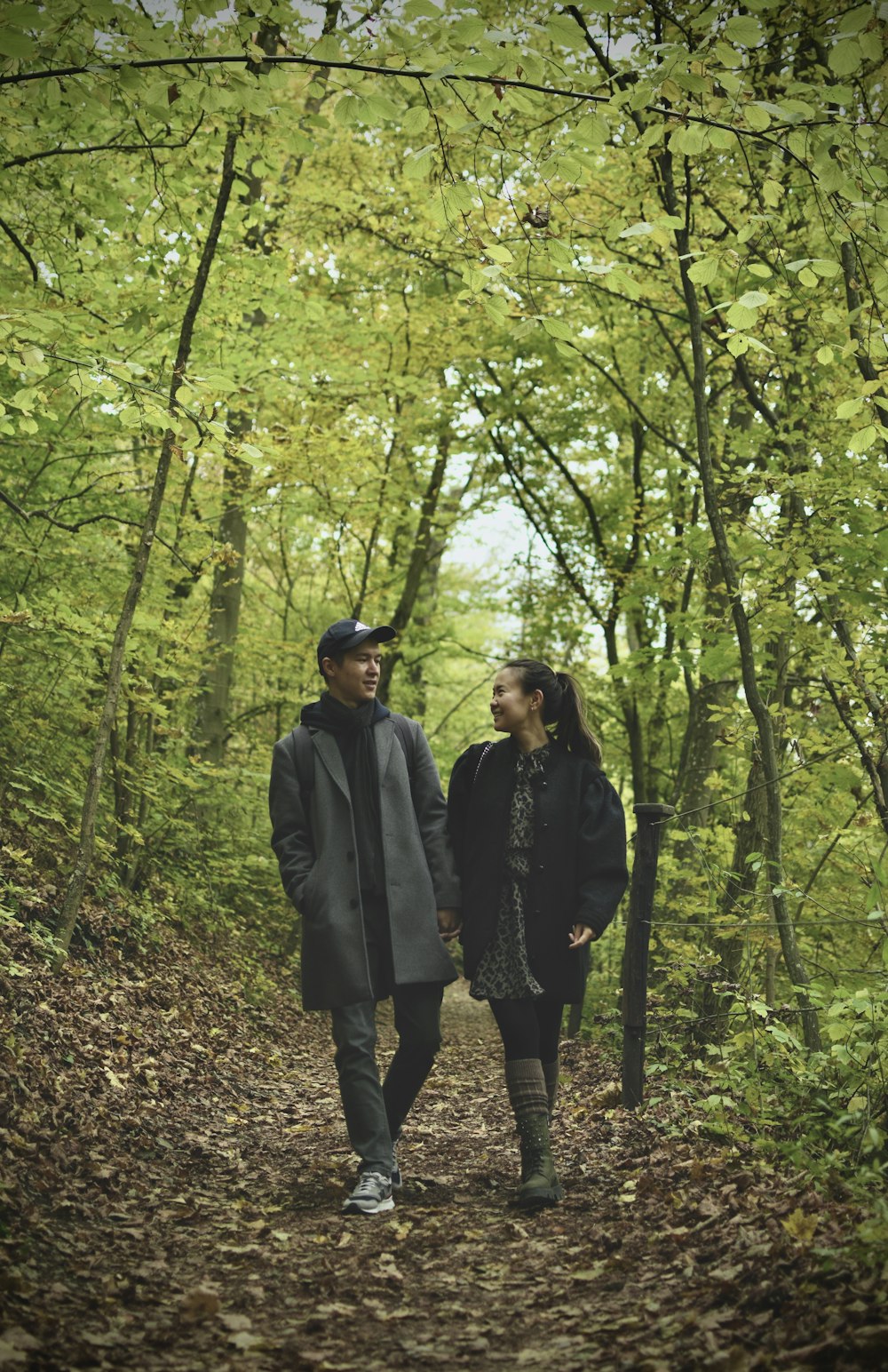 a man and a woman walking through a forest