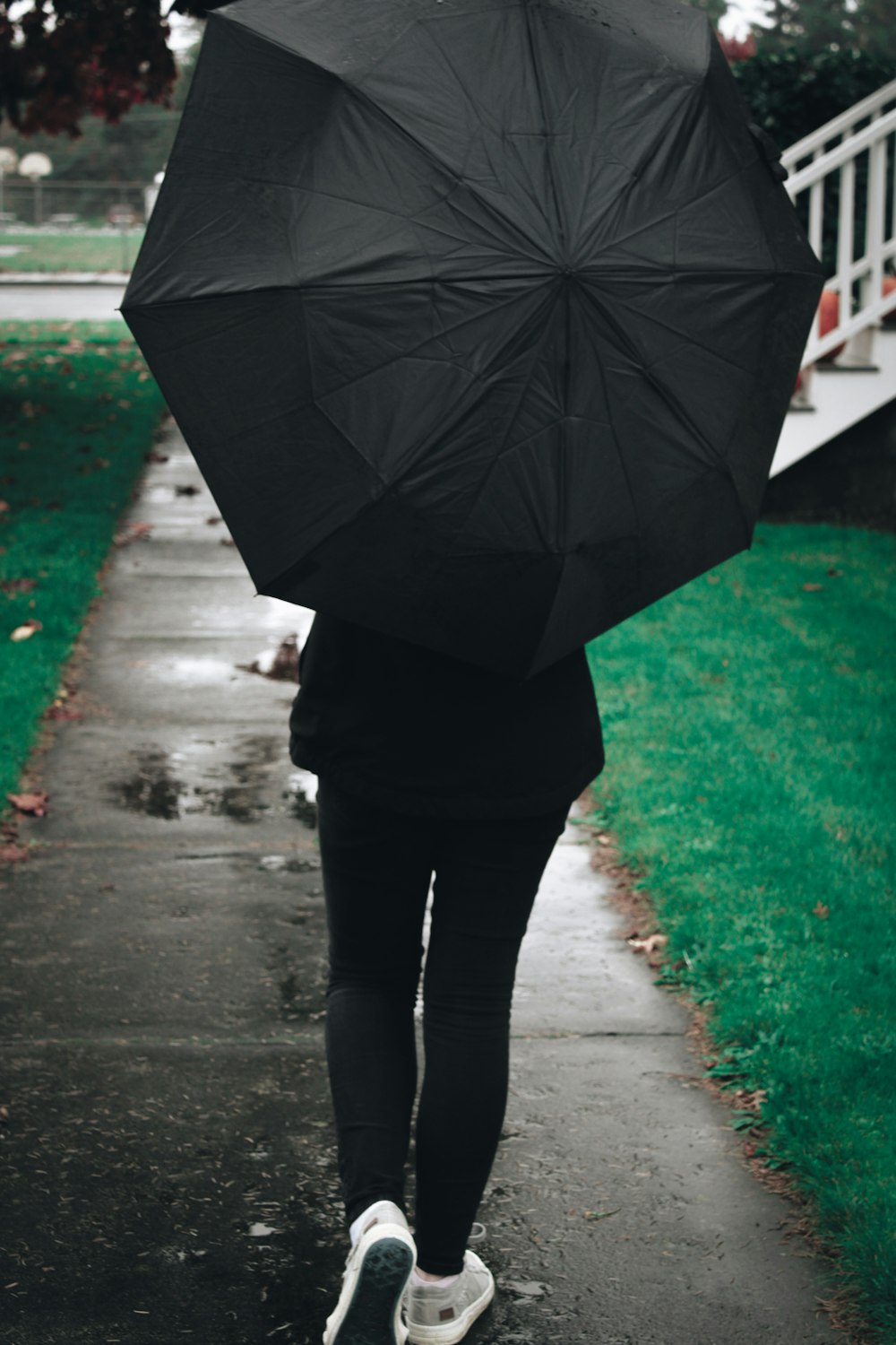 a person walking down a sidewalk with an umbrella