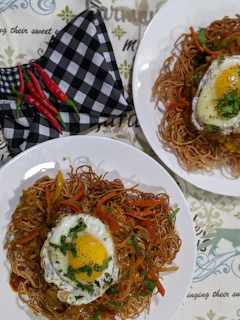 Close-up of a vibrant nasi goreng plate garnished with fresh herbs and a fried egg.