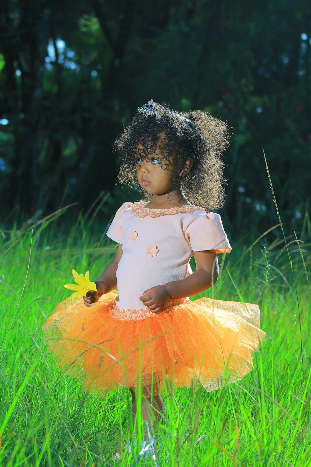 a little girl standing in a field of green grass