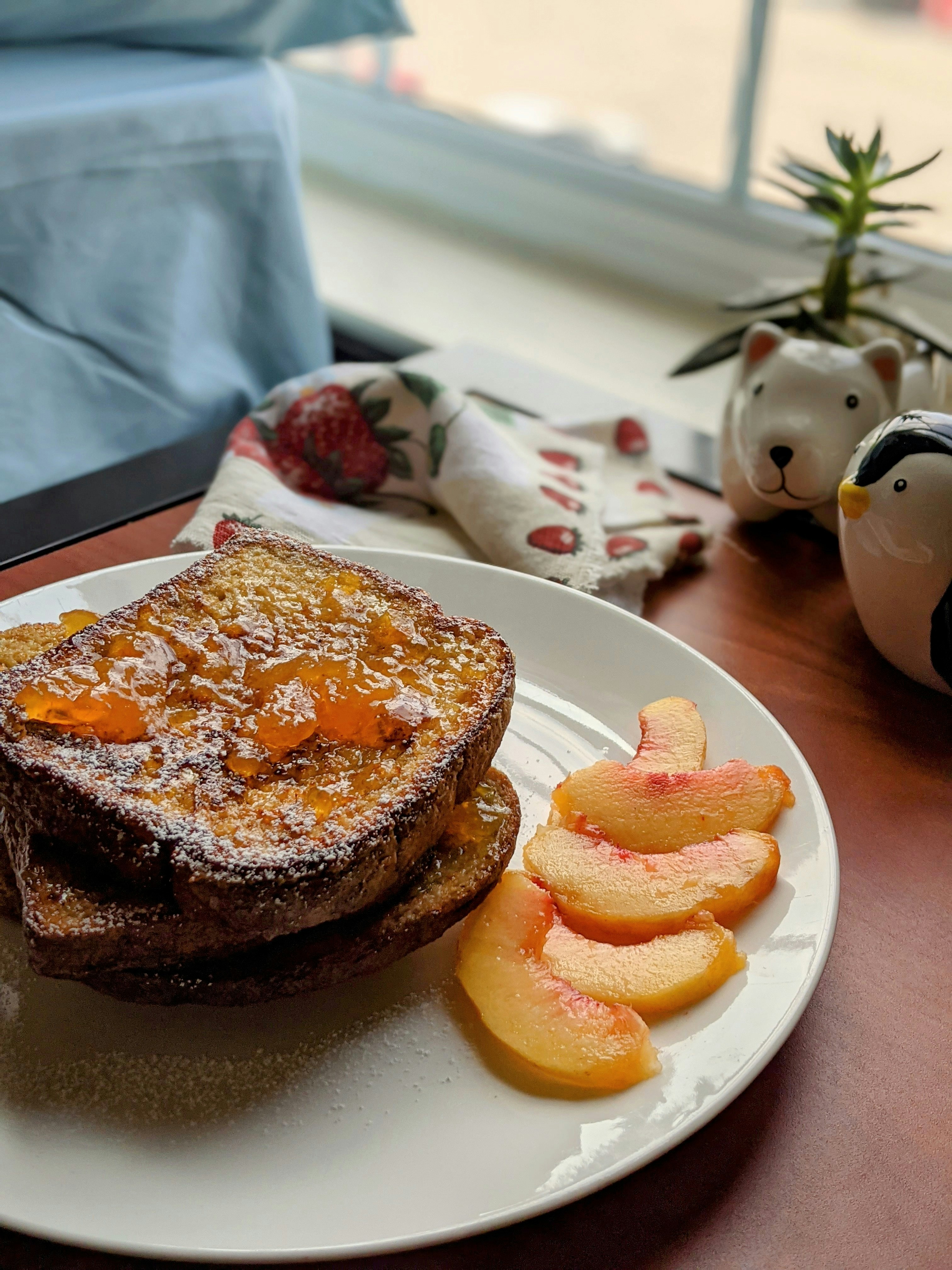 un piatto bianco condito con toast francesi e pesche affettate