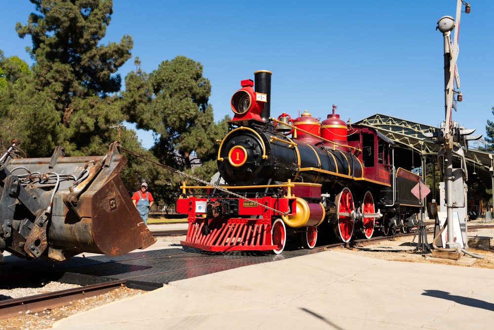a red and black train engine sitting on a track