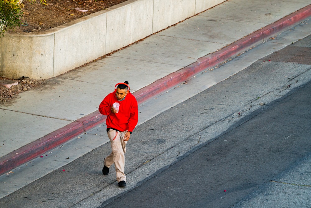 a man in a red jacket is walking down the street