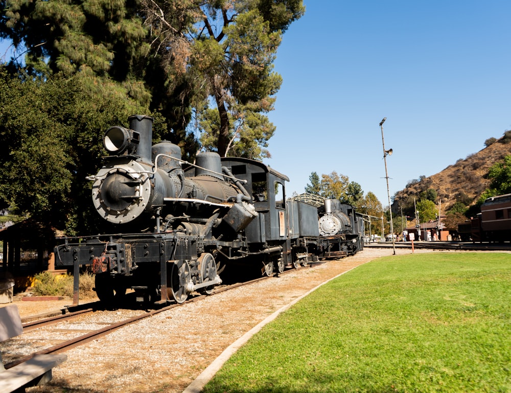 an old fashioned train is parked on the tracks