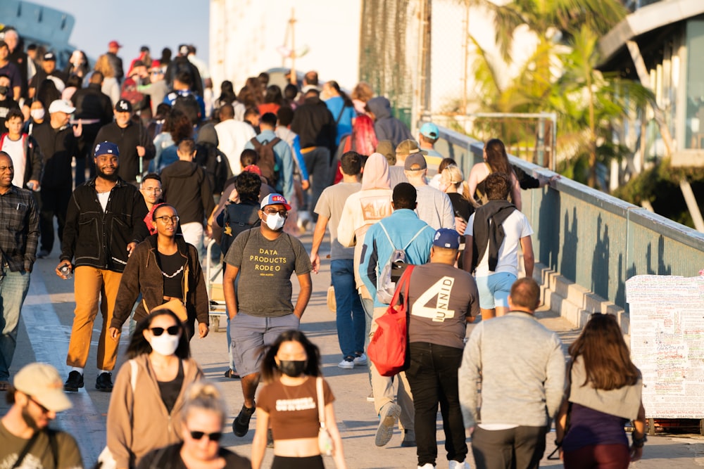 a large group of people walking down a sidewalk