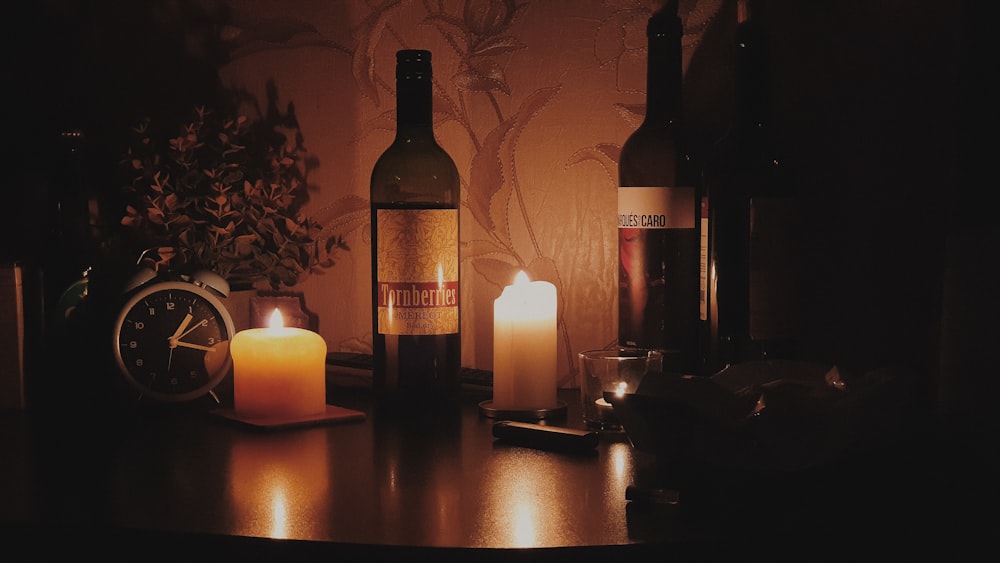 a table topped with bottles of wine and candles