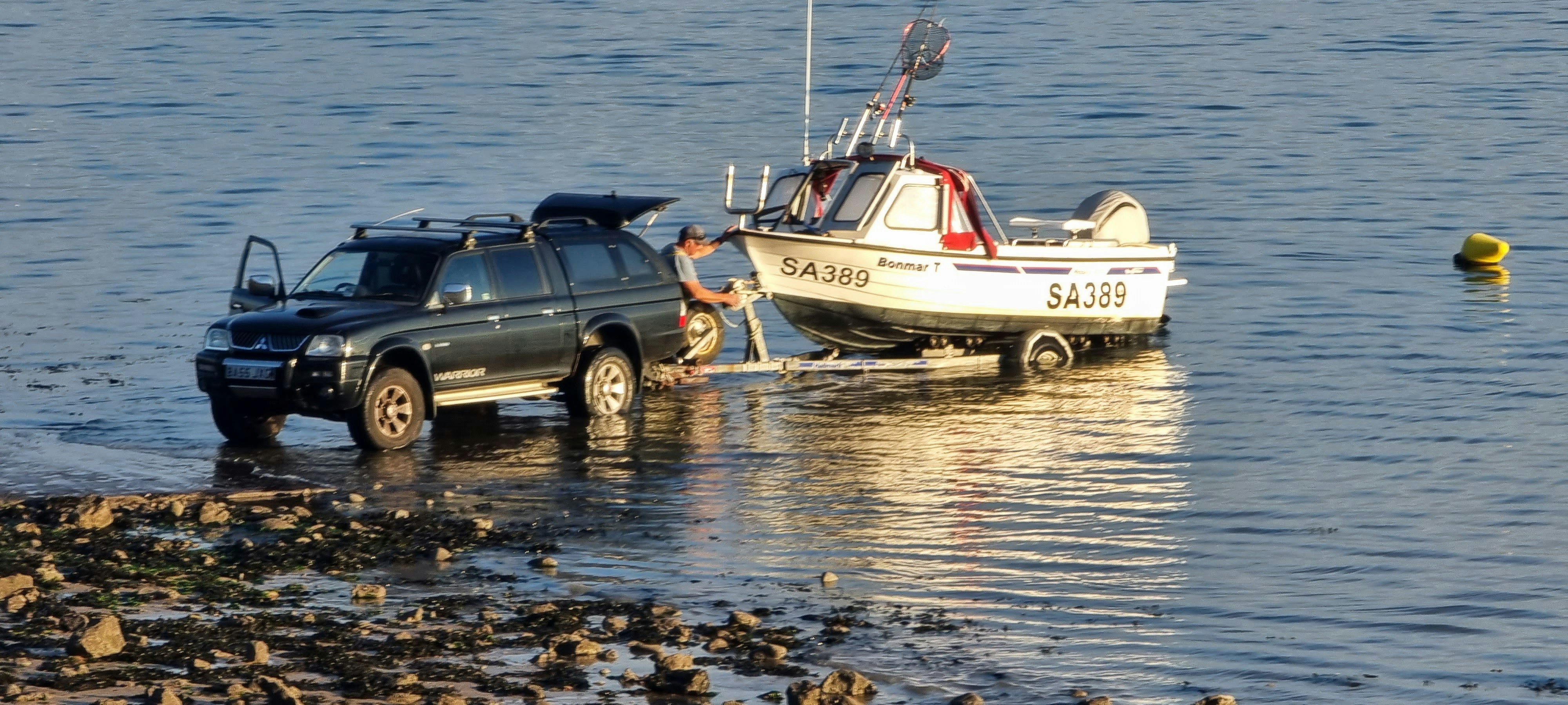 A truck pulling a boat out of the water photo Free Person Image on