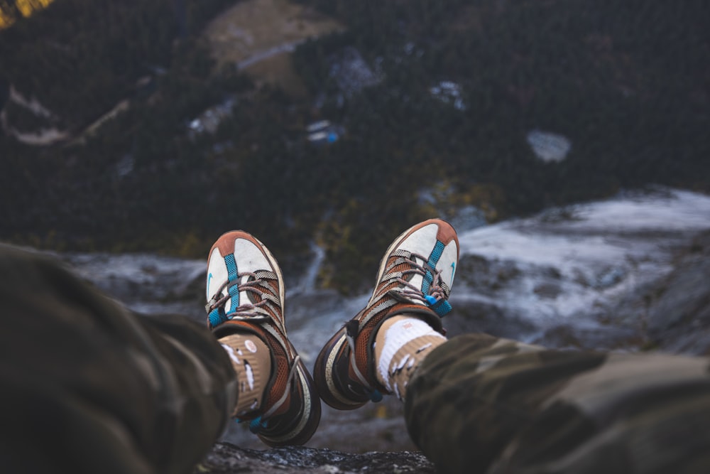 a person standing on top of a mountain with their feet in the air