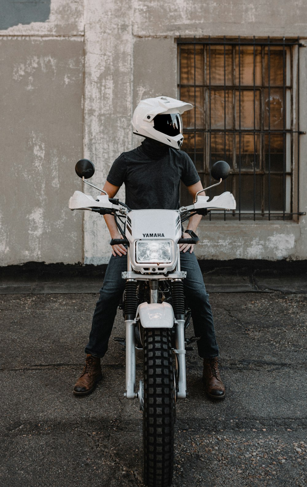 a person sitting on a motorcycle in front of a building