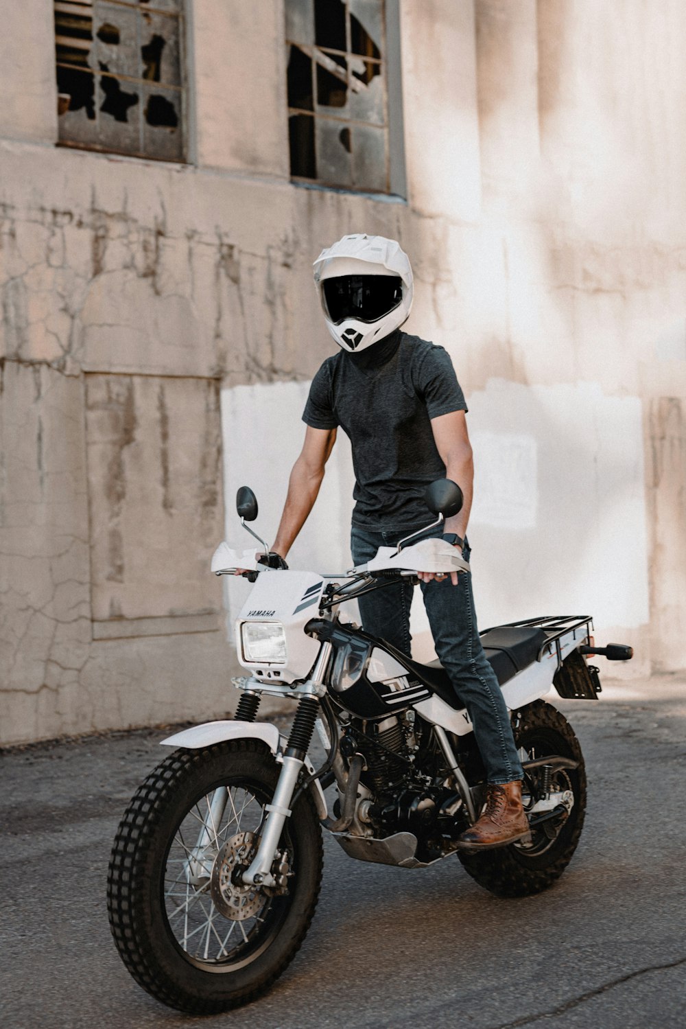 a man riding a motorcycle down a dirt road