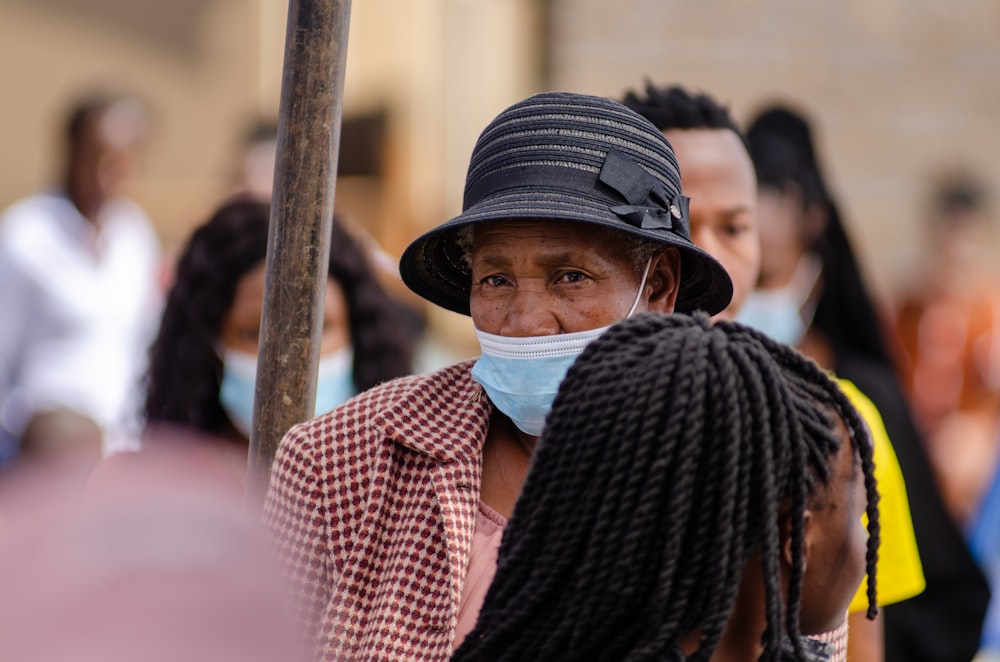 a woman wearing a face mask and a black hat