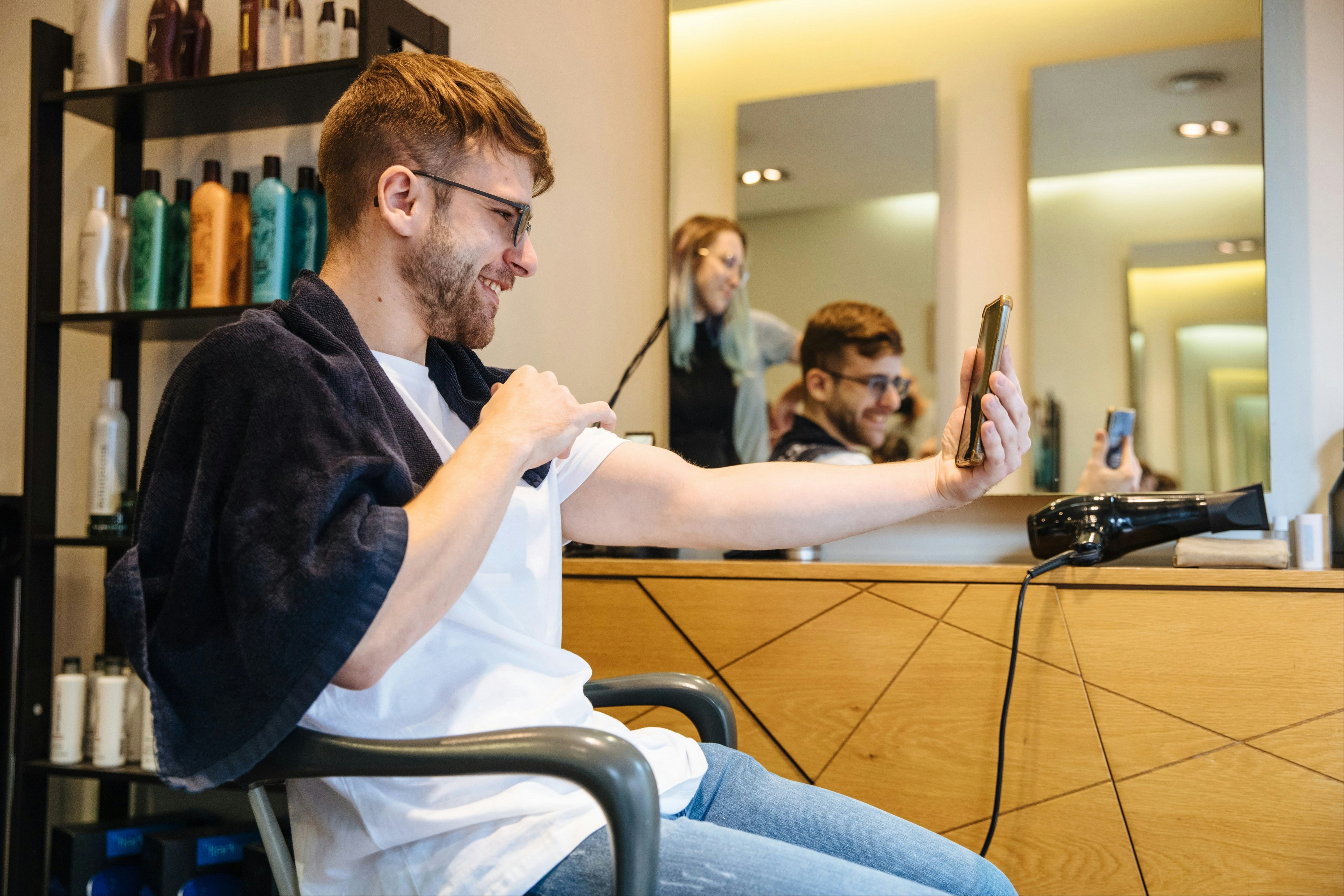 a man sitting in a chair in front of a mirror