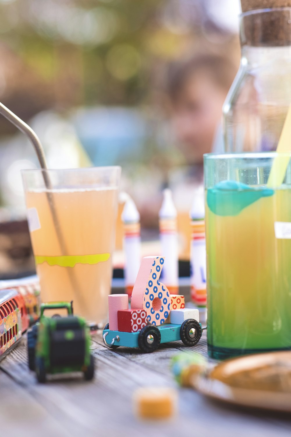 a table topped with toys and drinks on top of a wooden table