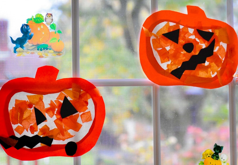a close up of a window with paper pumpkins