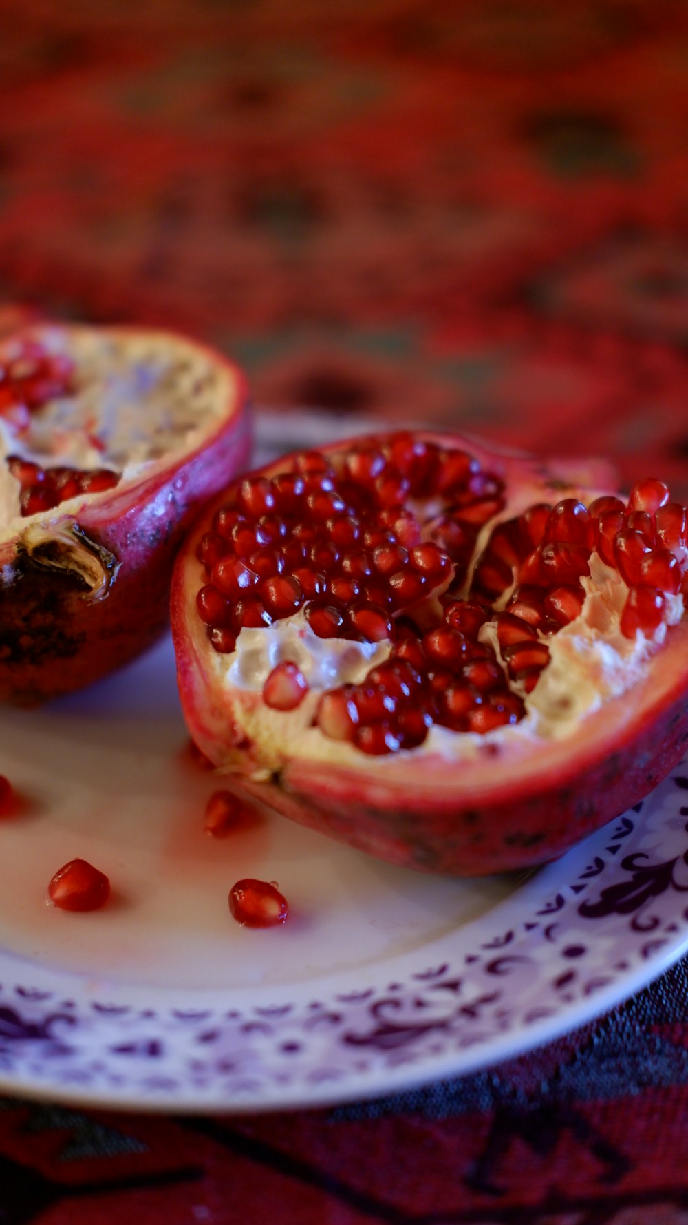 a white plate topped with a cut in half pomegranate