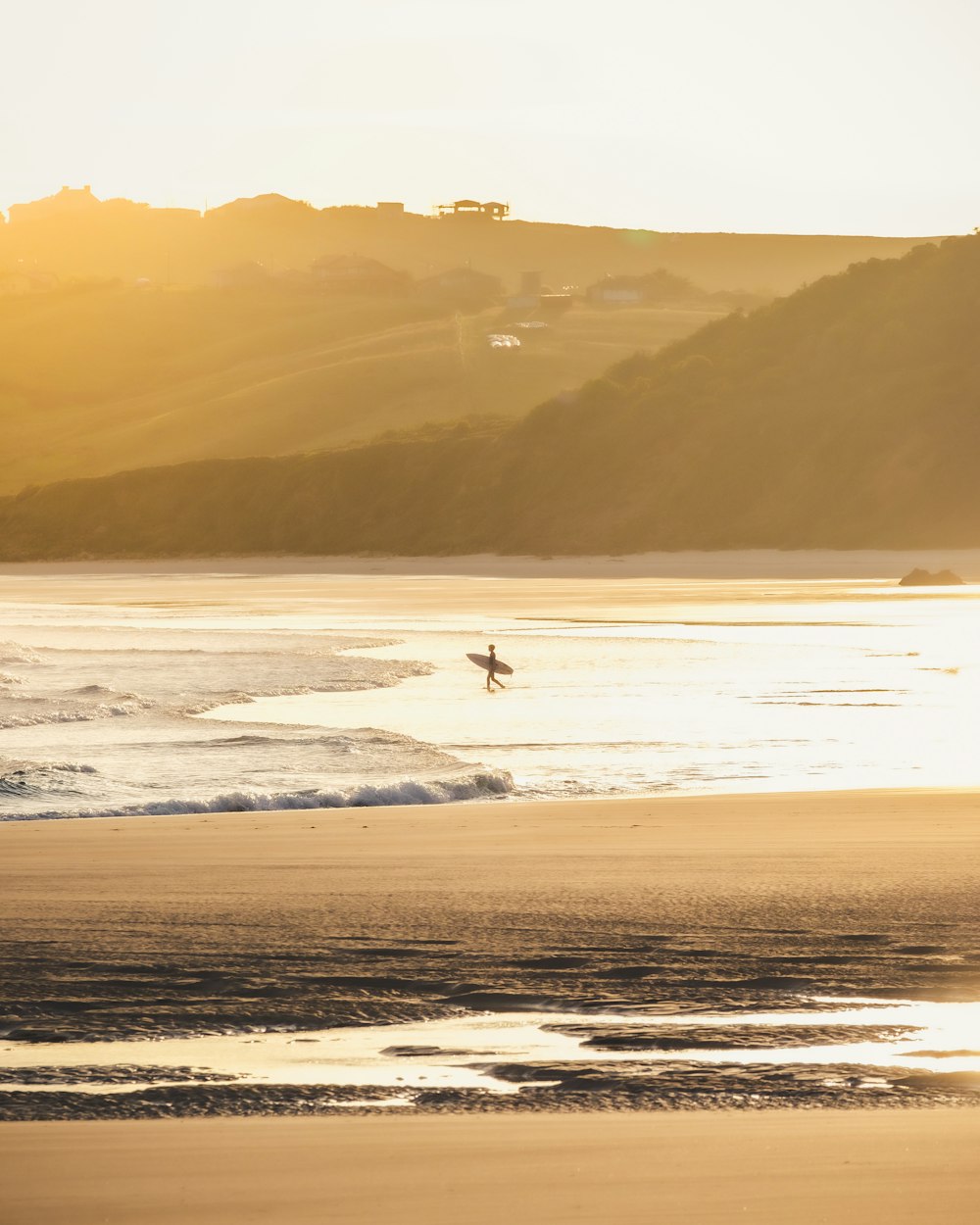 a person with a surfboard on a beach